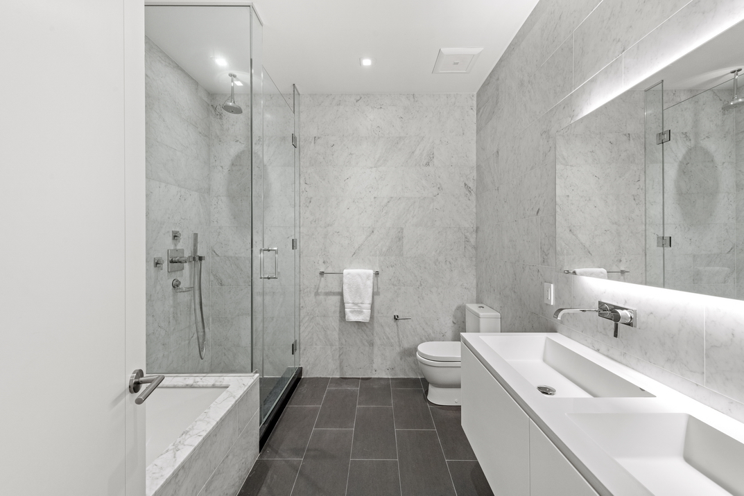 11 North Moore Street, Unit 2B Manhattan, NY 10013 - Photo 6 of 12 a bathroom with a double vanity sink a toilet and shower