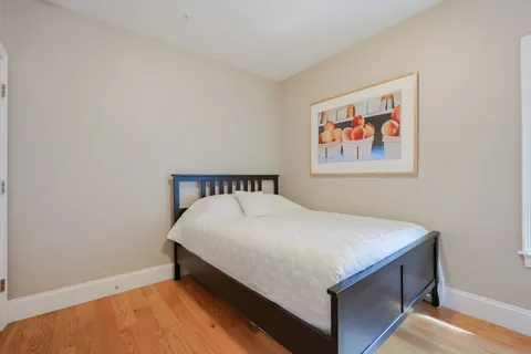 a bedroom with a bed and painting on the wall