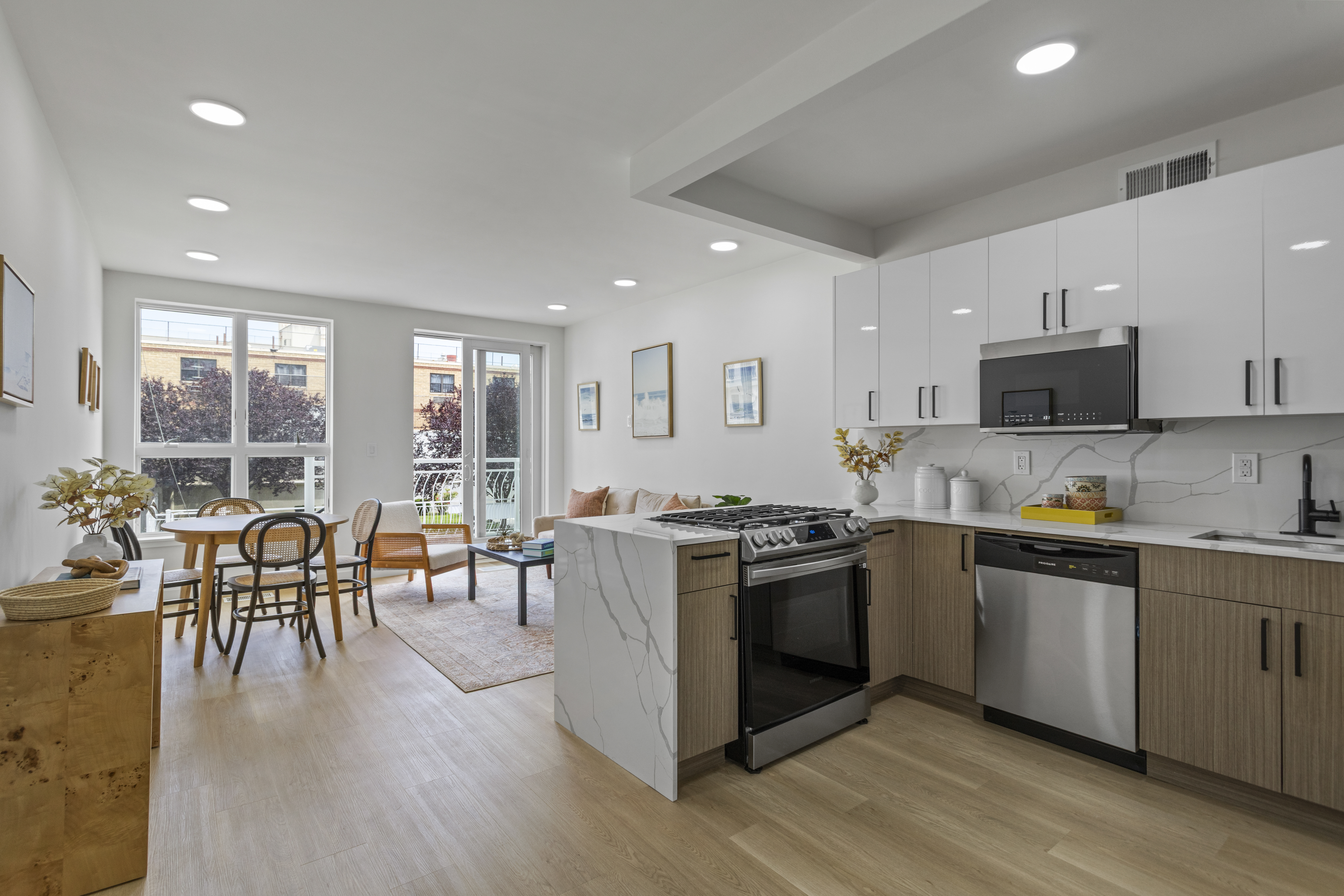 3112 Emmons Avenue, Unit 3140A-2 Brooklyn, NY 11235 - Photo 1 of 13 a open kitchen with stainless steel appliances granite countertop a stove top oven a sink dishwasher a dining table and chairs with wooden floor