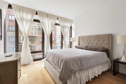 a bedroom with a large bed and a chandelier