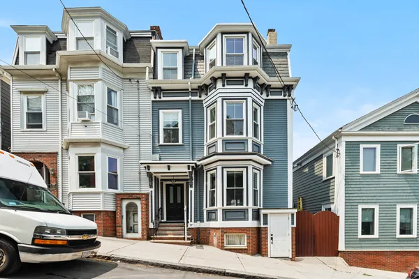 a front view of a residential apartment building with a yard