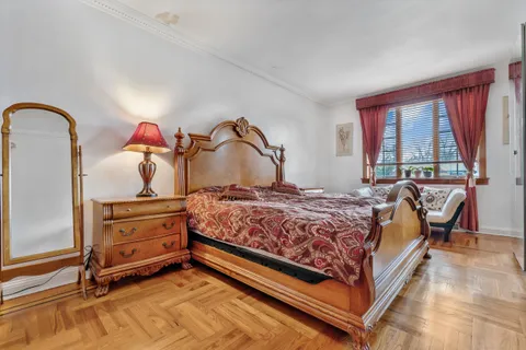 a bedroom with a bed and a dresser next to a window