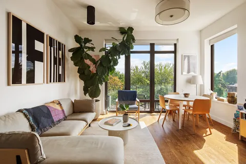 a living room with furniture and floor to ceiling windows