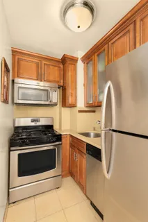 a kitchen with stainless steel appliances granite countertop a refrigerator sink and stove