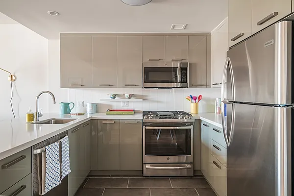 a kitchen with stainless steel appliances granite countertop a refrigerator sink and stove