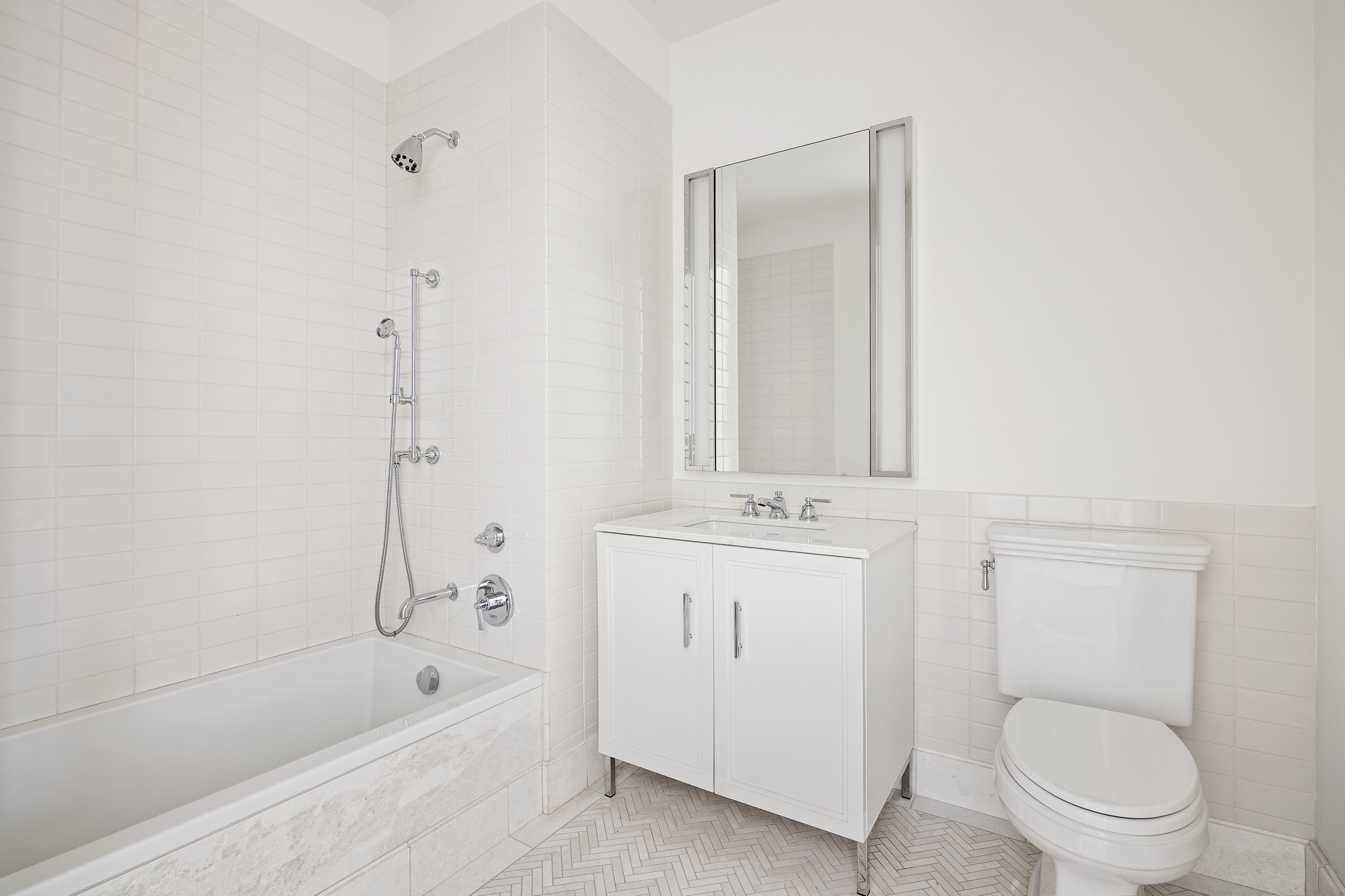 100 Barclay Street, Unit 16D Manhattan, NY 10007 - Photo 9 of 14 a bathroom with a toilet a sink a mirror and bathtub