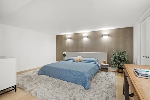 a bedroom with a bed and a potted plant