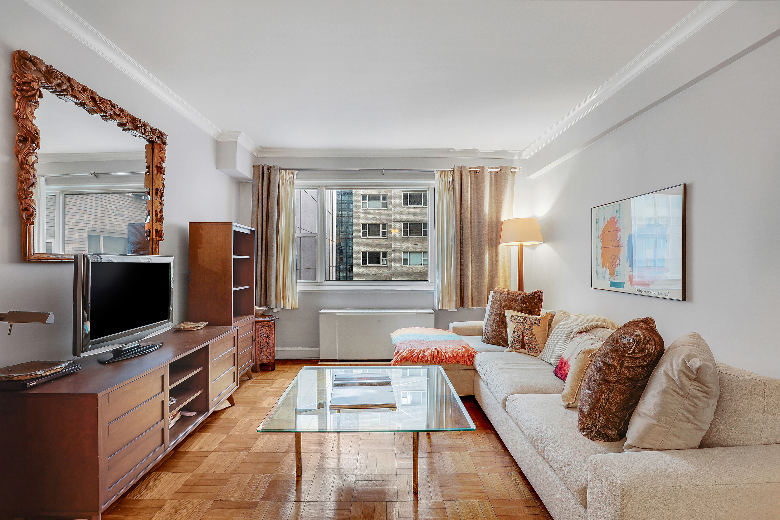 100 West 57th Street, Unit 15N Manhattan, NY 10019 - Photo 1 of 9 a living room with furniture and a flat screen tv