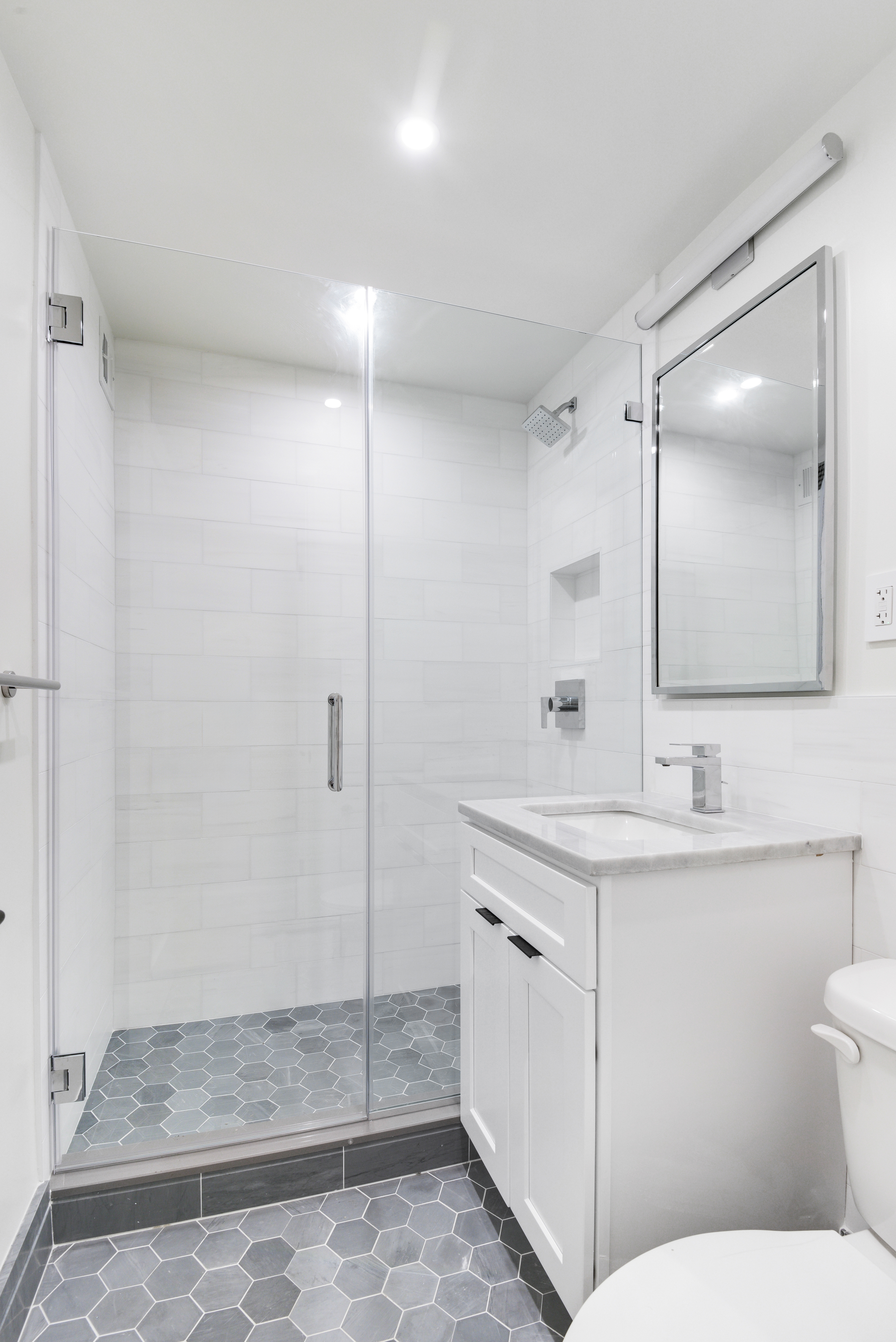 205 West End Avenue, Unit 15H Manhattan, NY 10023 - Photo 13 of 17 a bathroom with a sink a toilet a mirror and shower