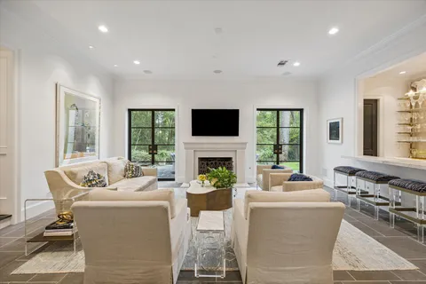 a living room with fireplace furniture and a large window