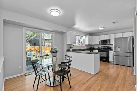 a kitchen with a table chairs refrigerator and microwave