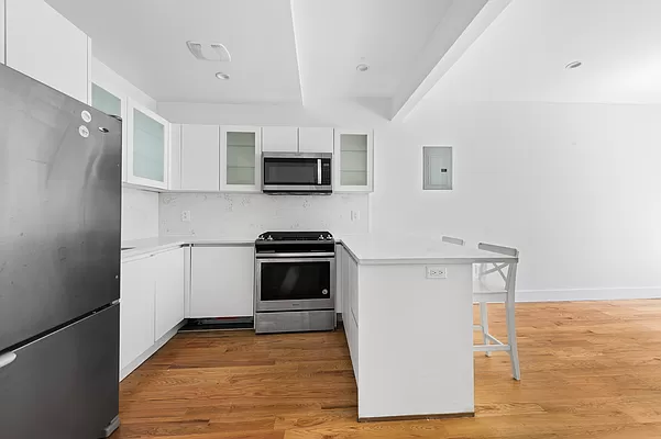 18 A Bleecker Street, Unit 4B Brooklyn, NY 11221 - Photo 6 of 11 a kitchen with stainless steel appliances a refrigerator stove and microwave