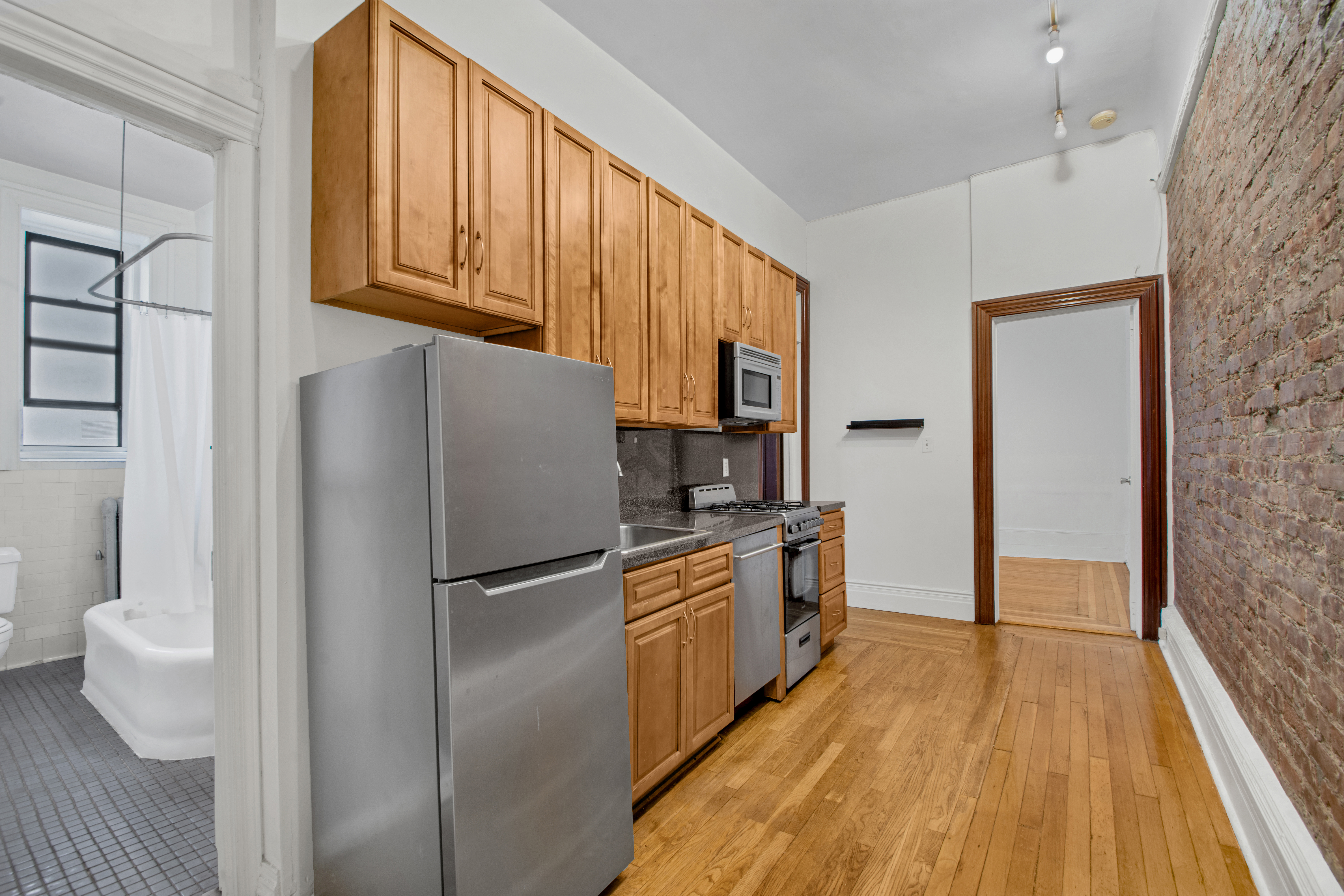 244 Riverside Drive, Unit 4D Manhattan, NY 10025 - Photo 7 of 9 a kitchen with stainless steel appliances granite countertop a refrigerator a stove and a wooden floors