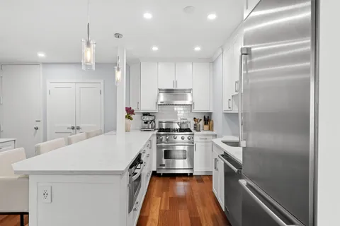 a kitchen with white cabinets and stainless steel appliances