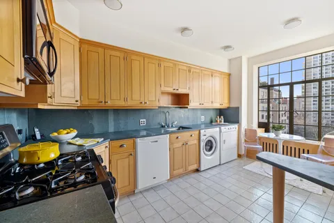 a kitchen with stainless steel appliances granite countertop a stove a sink and a granite counter tops with white cabinets