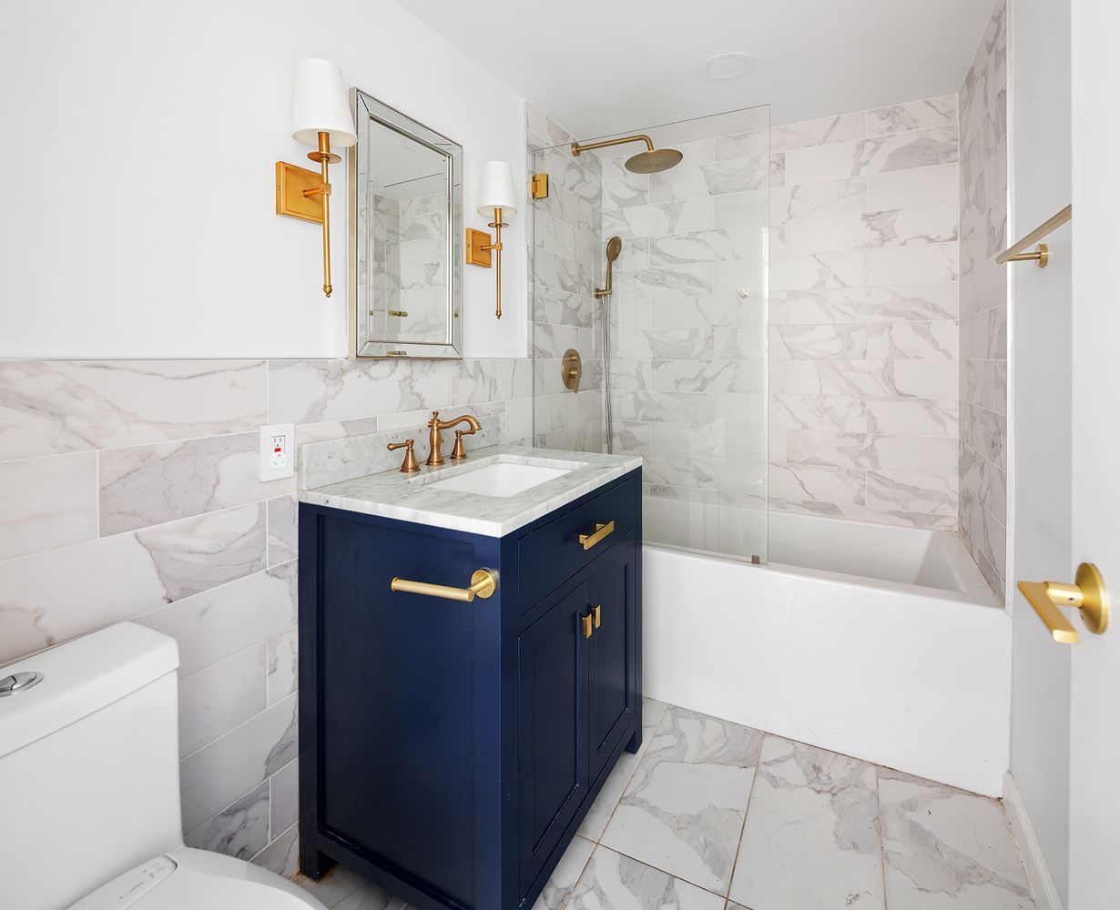 a bathroom with a sink a toilet and shower