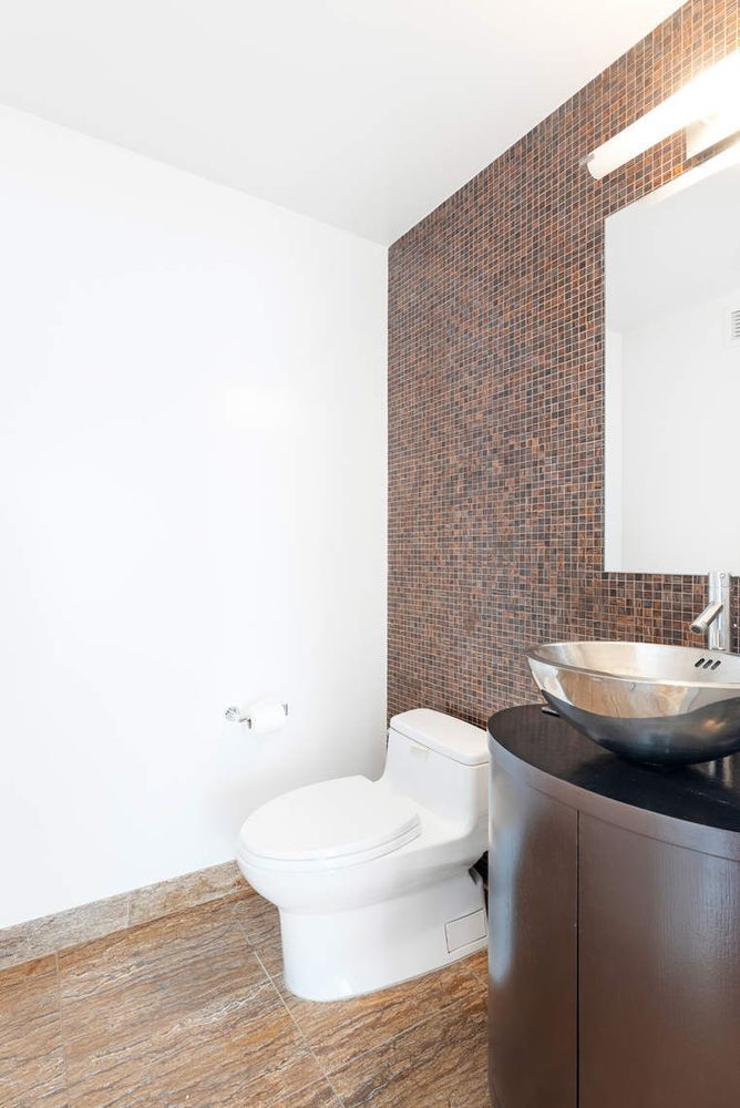 250 East 53rd Street, Unit 1001 Manhattan, NY 10022 - Photo 12 of 18 a bathroom with a sink and toilet