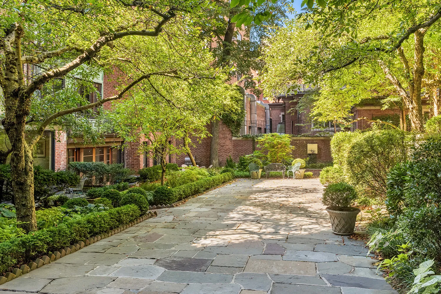 a pathway of a house with a yard and large trees