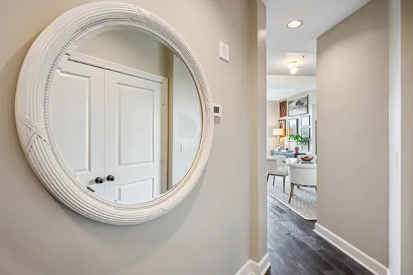 an empty room with wooden floor mirror and windows