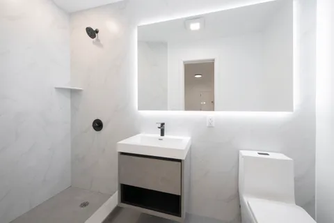 a bathroom with a sink a toilet and shower