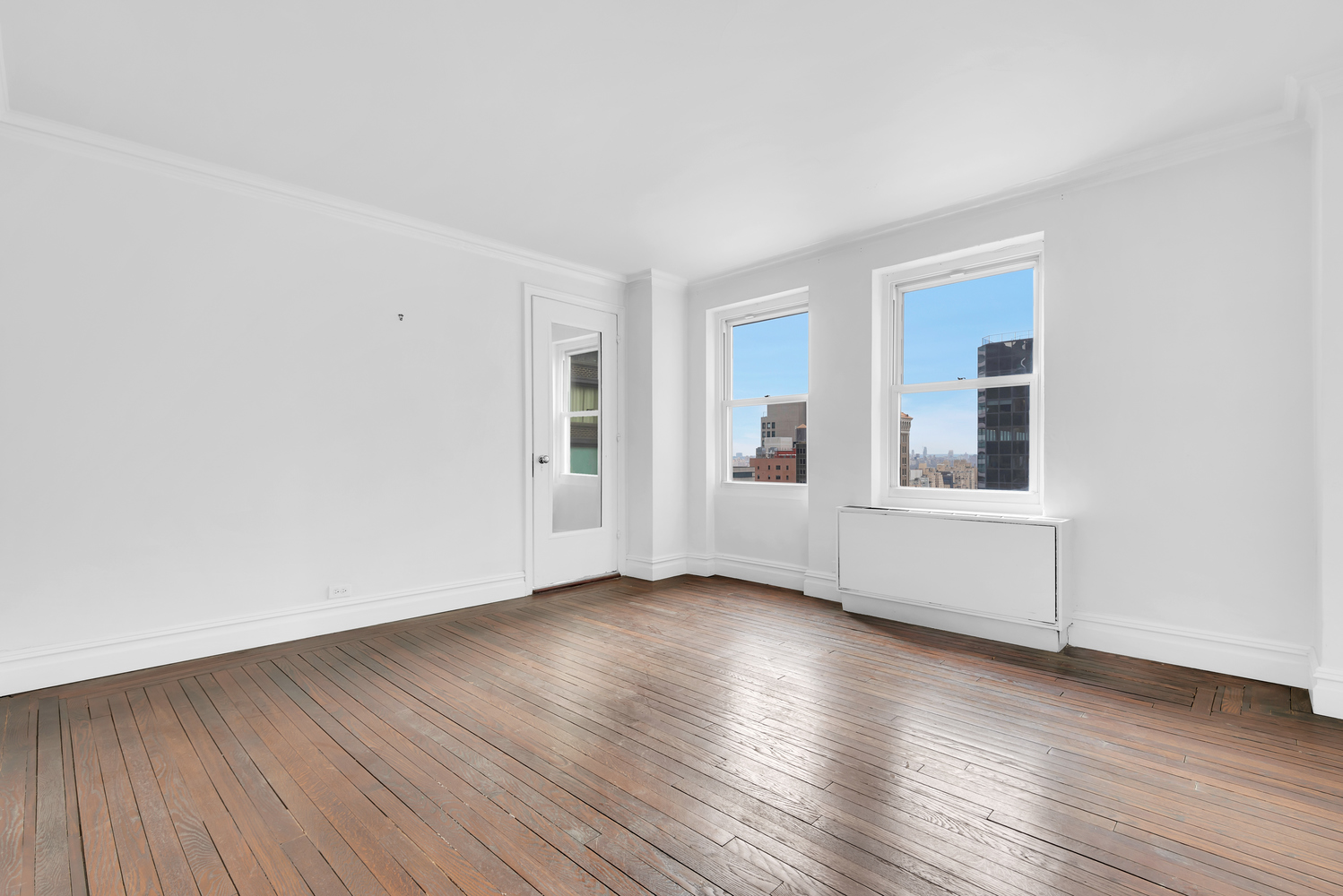465 Park Avenue, Unit 26C Manhattan, NY 10022 - Photo 8 of 10 a view of an empty room with wooden floor and a window