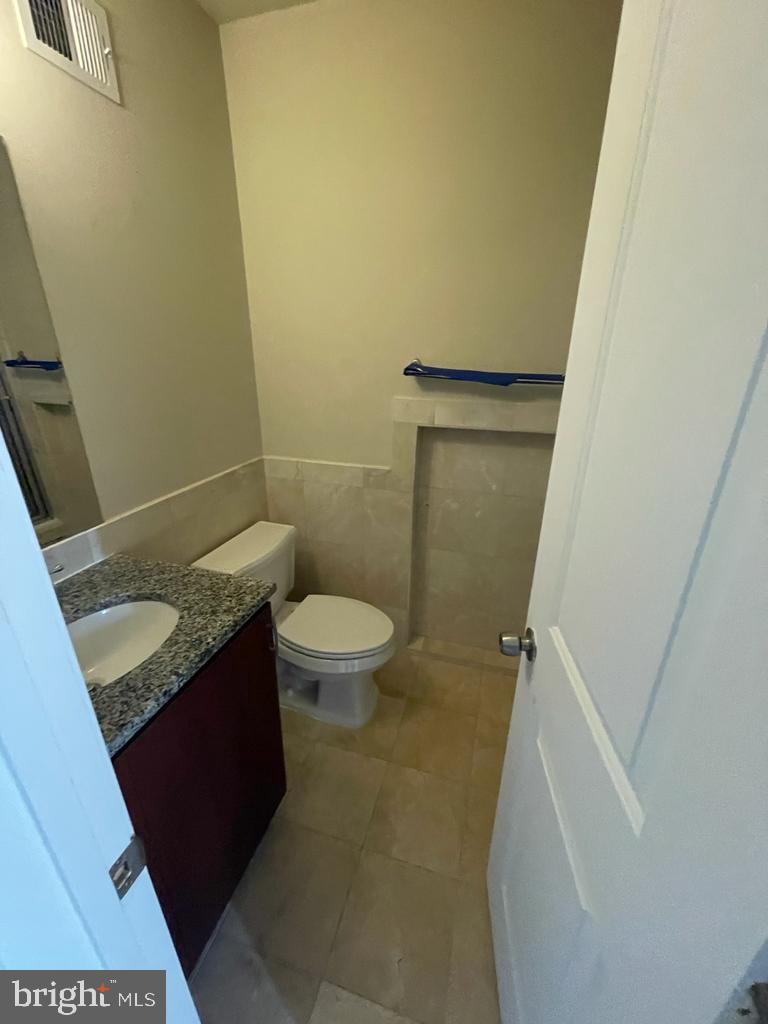 1033 Park Road Northwest, Unit 6 Washington, DC 20010 - Photo 11 of 38 a bathroom with a granite countertop sink and a toilet