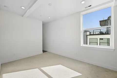 an empty room with a fireplace and a large window