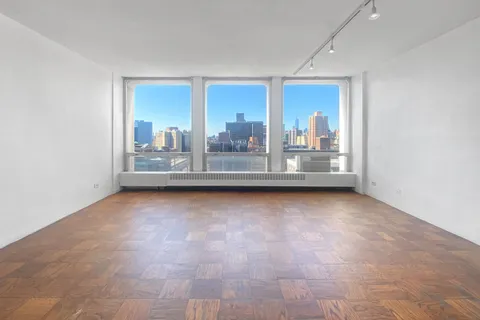 a view of a living room hardwood floor and a window