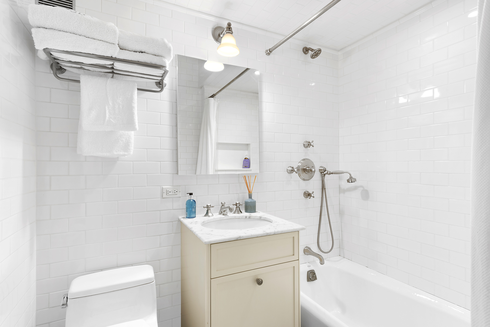 165 East 72nd Street, Unit 3L Manhattan, NY 10021 - Photo 9 of 13 a bathroom with a sink a mirror toilet and bathtub