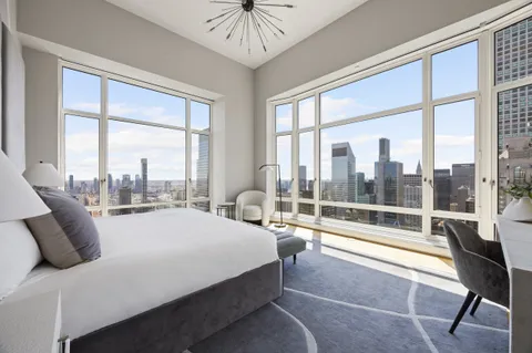 a bedroom with a bed and a large window with outer view