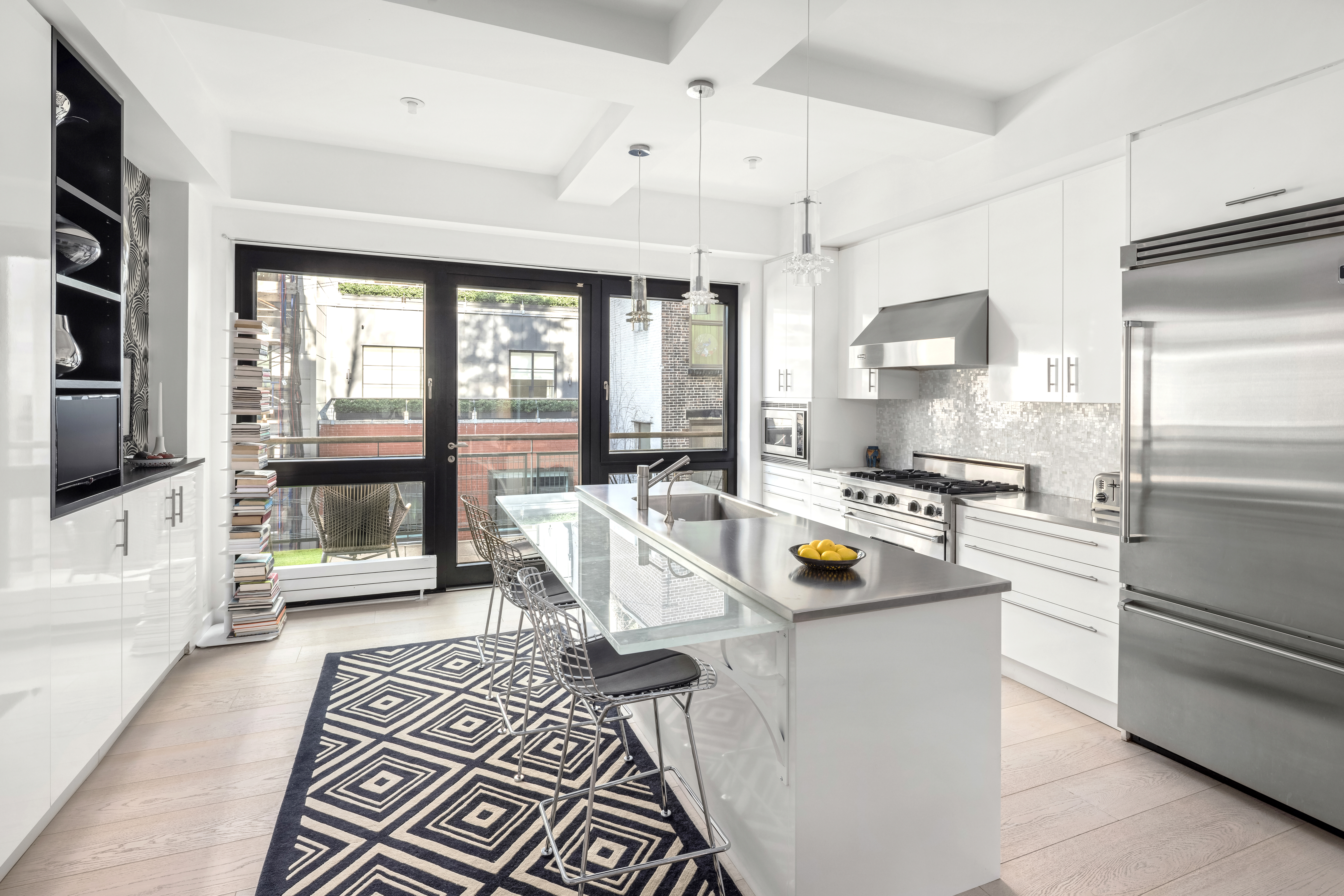 138 Reade Street, Unit 5 Manhattan, NY 10013 - Photo 7 of 23 a kitchen that has a lot of white cabinets and stainless steel appliances