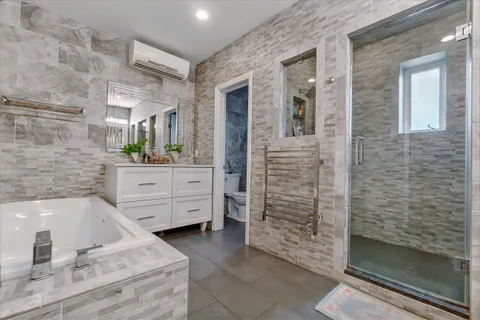 a bathroom with a tub sink and mirror