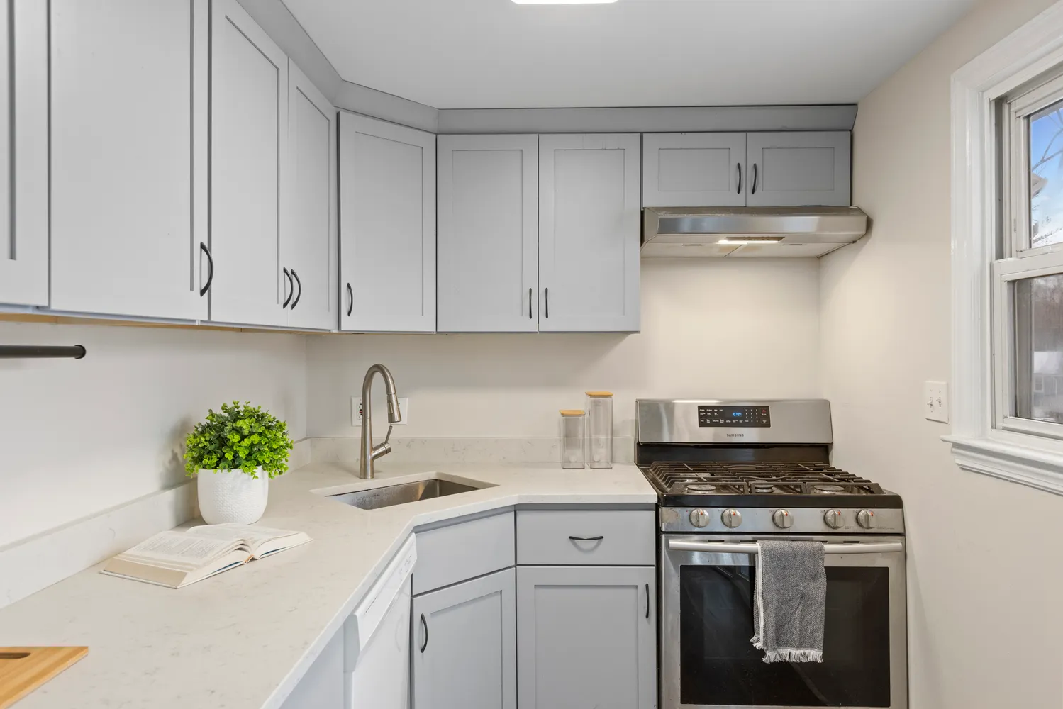 a kitchen with stainless steel appliances white cabinets and a stove top oven