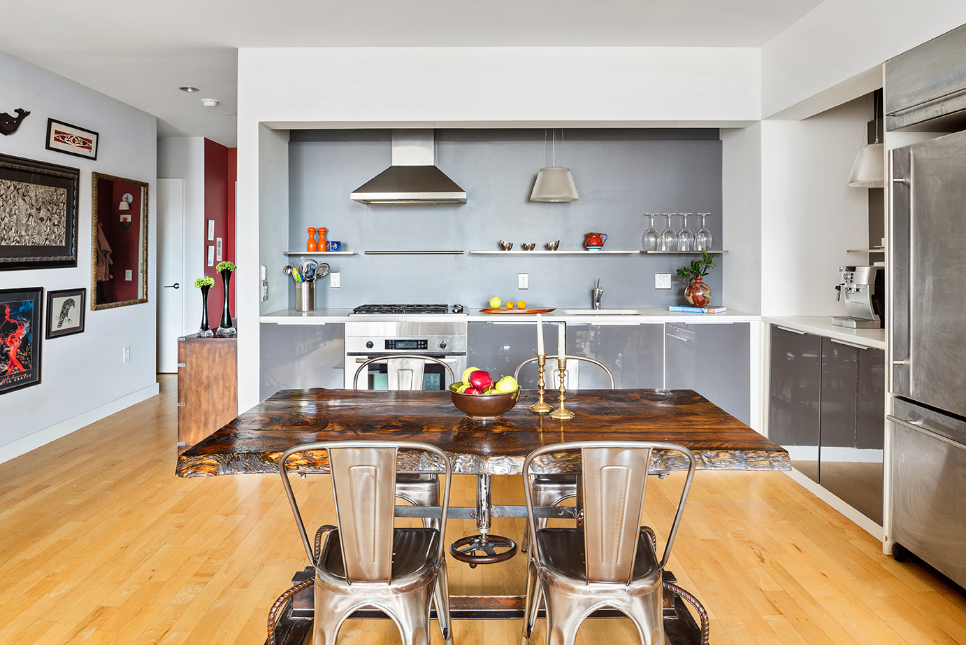 15 Broad Street, Unit 3214 Manhattan, NY 10005 - Photo 3 of 9 a kitchen with stainless steel appliances a table and chairs in it