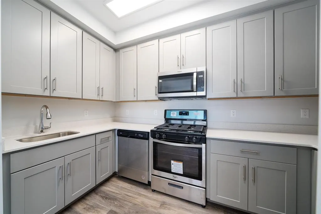 a kitchen with cabinets appliances a sink and a window