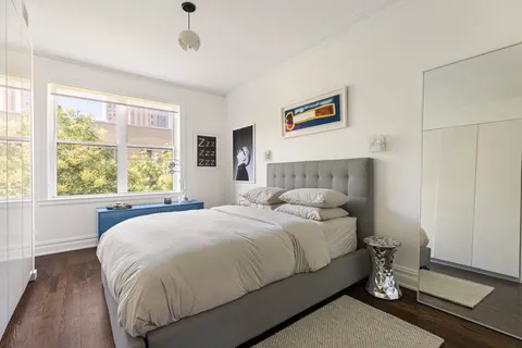 a room with a baby crib and dresser