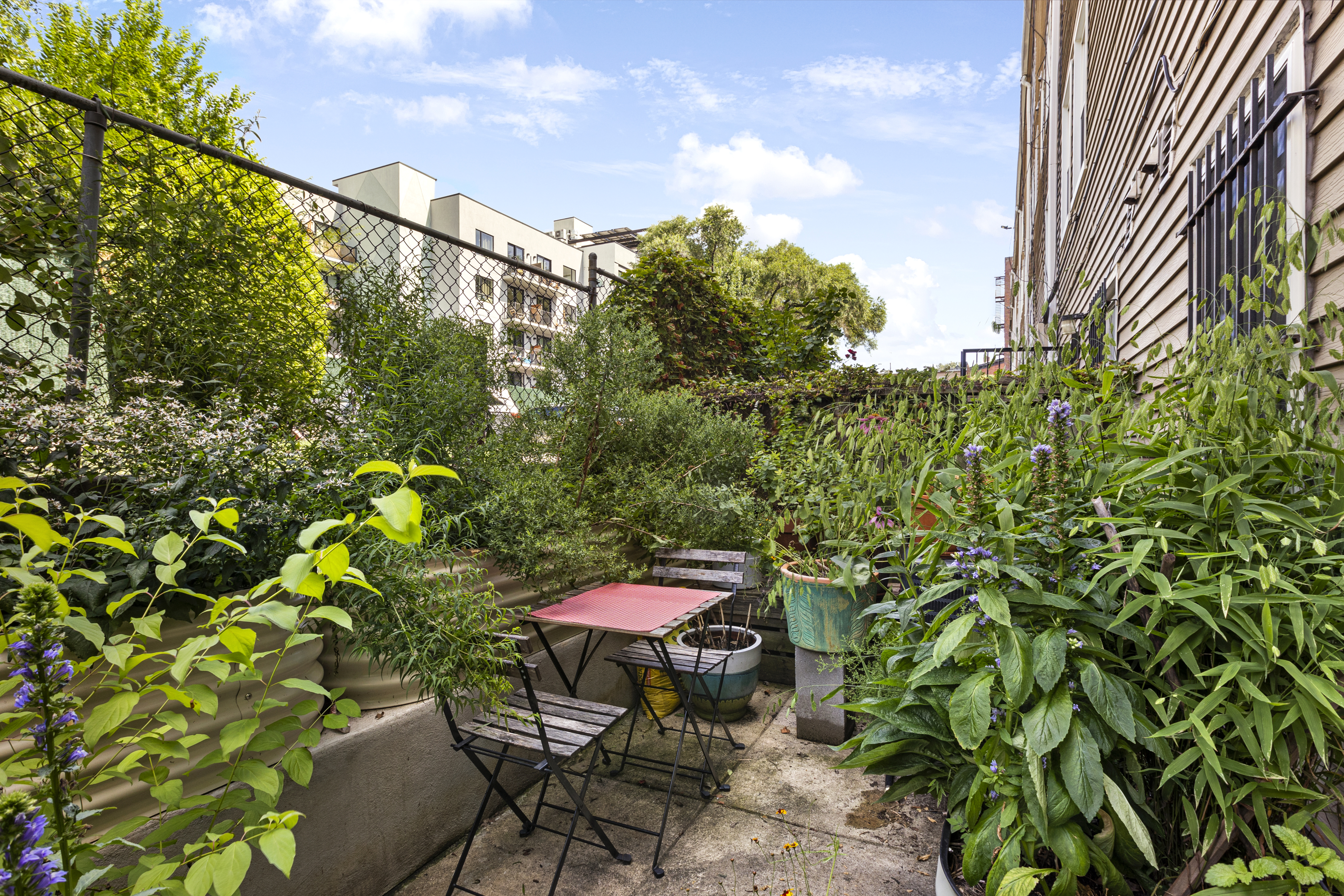 329 Grand Avenue, Unit B Brooklyn, NY 11238 - Photo 2 of 9 a patio with table and chairs and potted plants