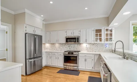 a kitchen with stainless steel appliances granite countertop a refrigerator sink and stove