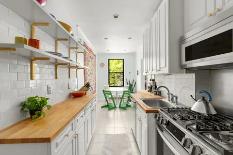 a kitchen with stainless steel appliances a stove a sink and a microwave