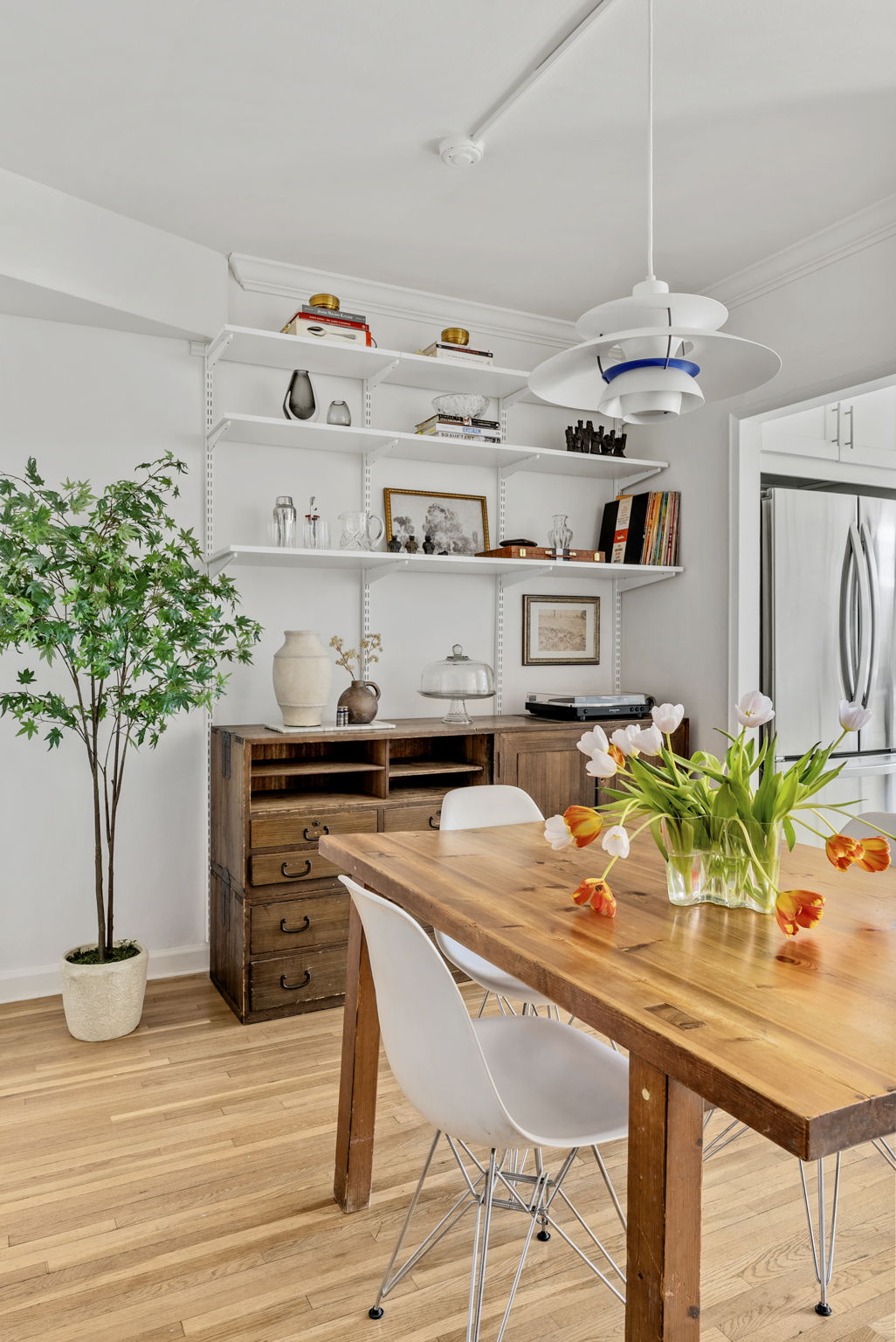 675 Academy Street, Unit 5E Manhattan, NY 10034 - Photo 4 of 10 a kitchen with stainless steel appliances potted plants and wooden floor
