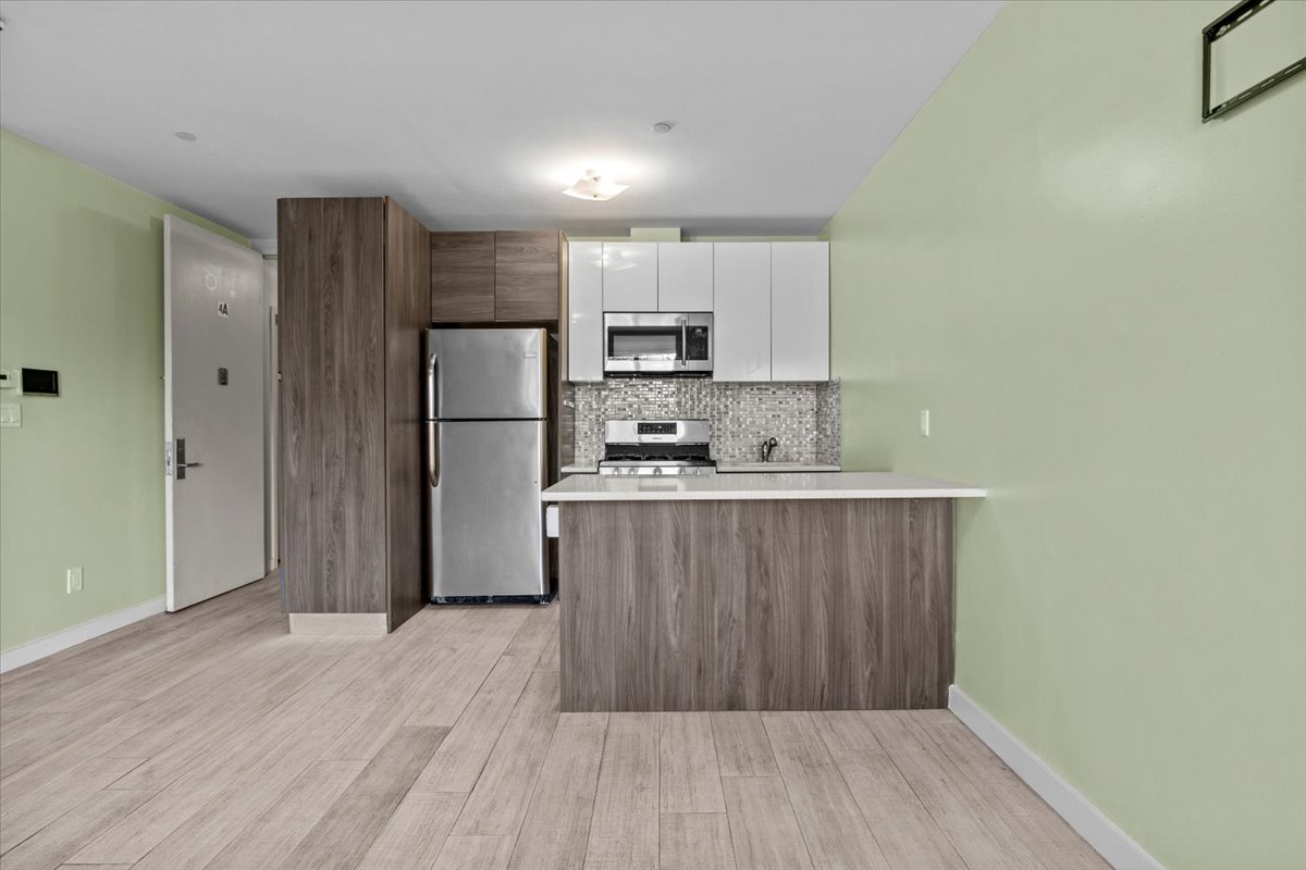 1972 Ocean Avenue, Unit 4A Brooklyn, NY 11230 - Photo 5 of 18 a kitchen with stainless steel appliances granite countertop a refrigerator and a stove top oven