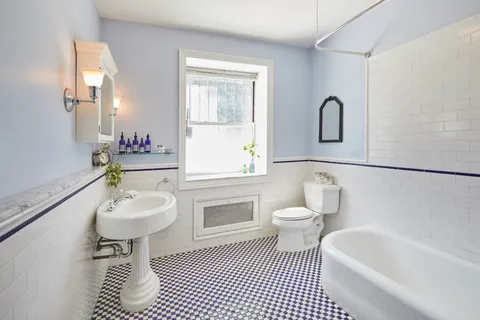 a bathroom with a sink a toilet and a mirror