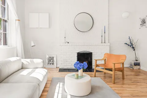 a living room with furniture a fireplace and a large window