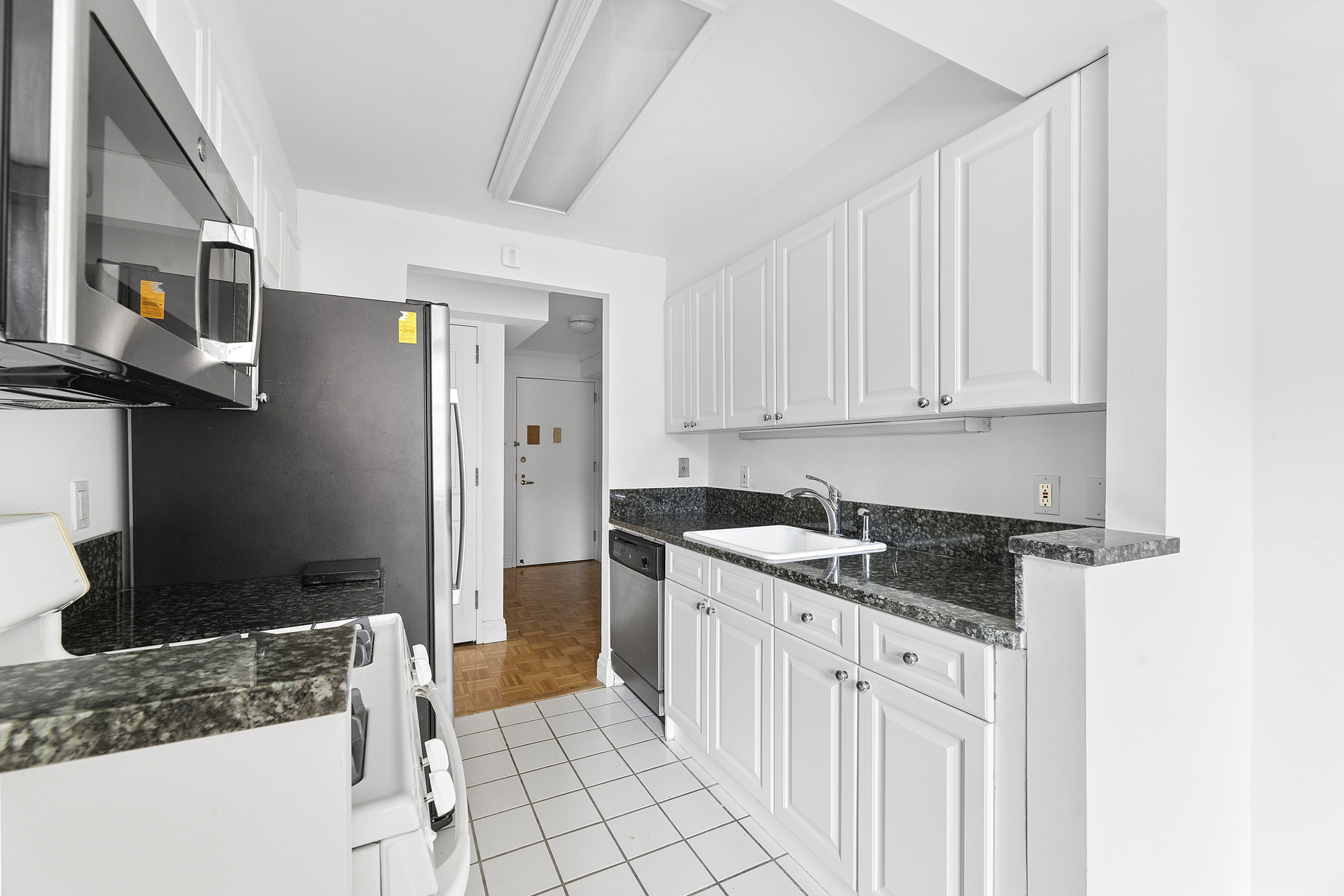 404 East 76th Street, Unit 4E Manhattan, NY 10021 - Photo 3 of 6 a kitchen that has a sink and a stove