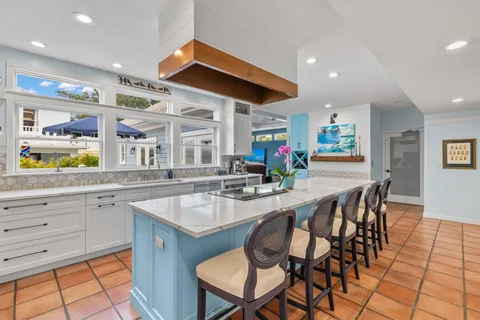 a kitchen with granite countertop a stove a sink and a refrigerator