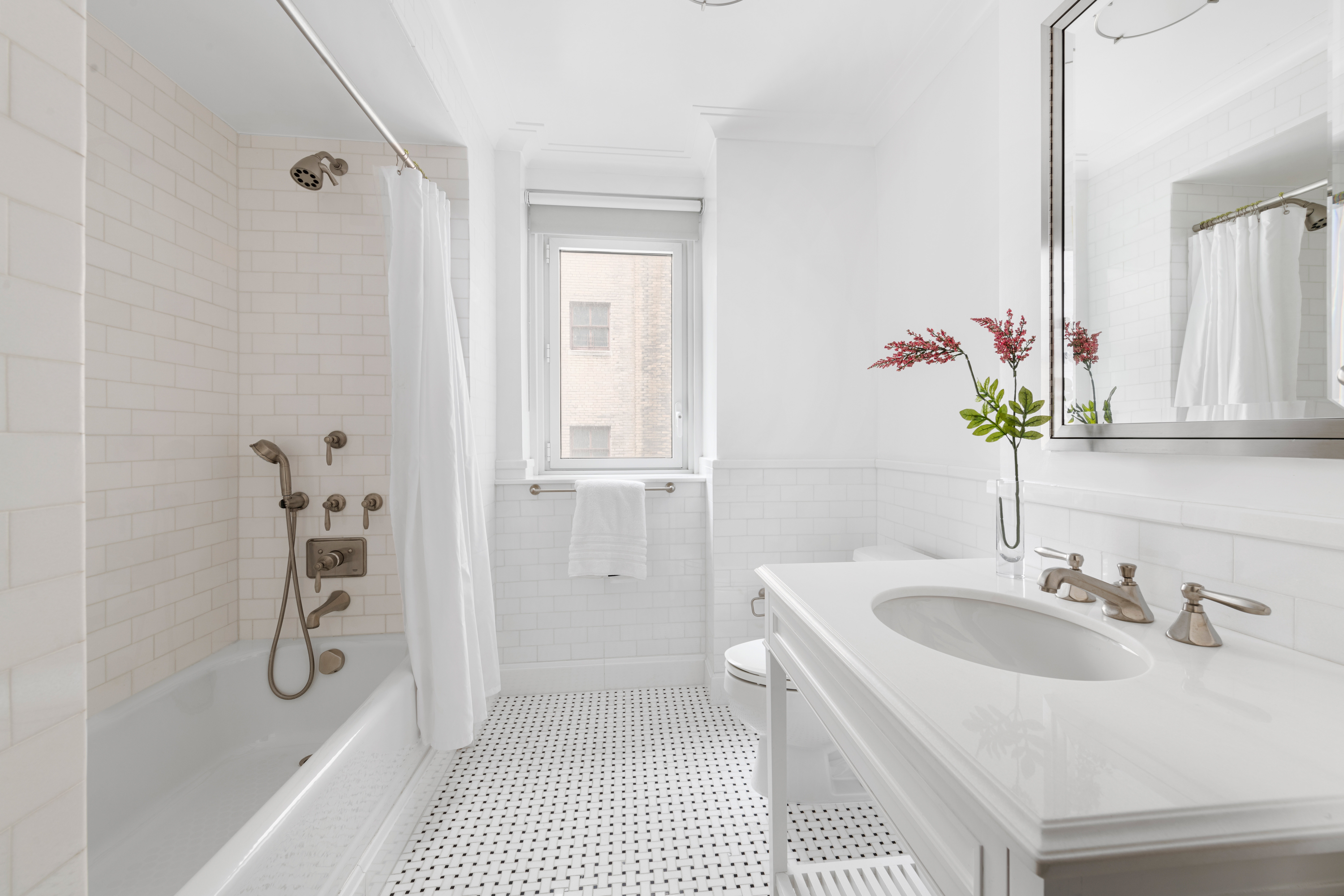 530 Park Avenue, Unit 12F Manhattan, NY 10065 - Photo 17 of 26 a bathroom with a sink a mirror and a shower