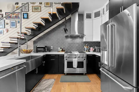 a kitchen with stainless steel appliances granite countertop a stove a sink and a refrigerator