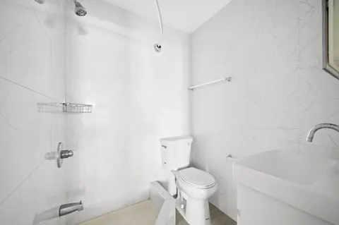 a white toilet sitting next to a bath tub