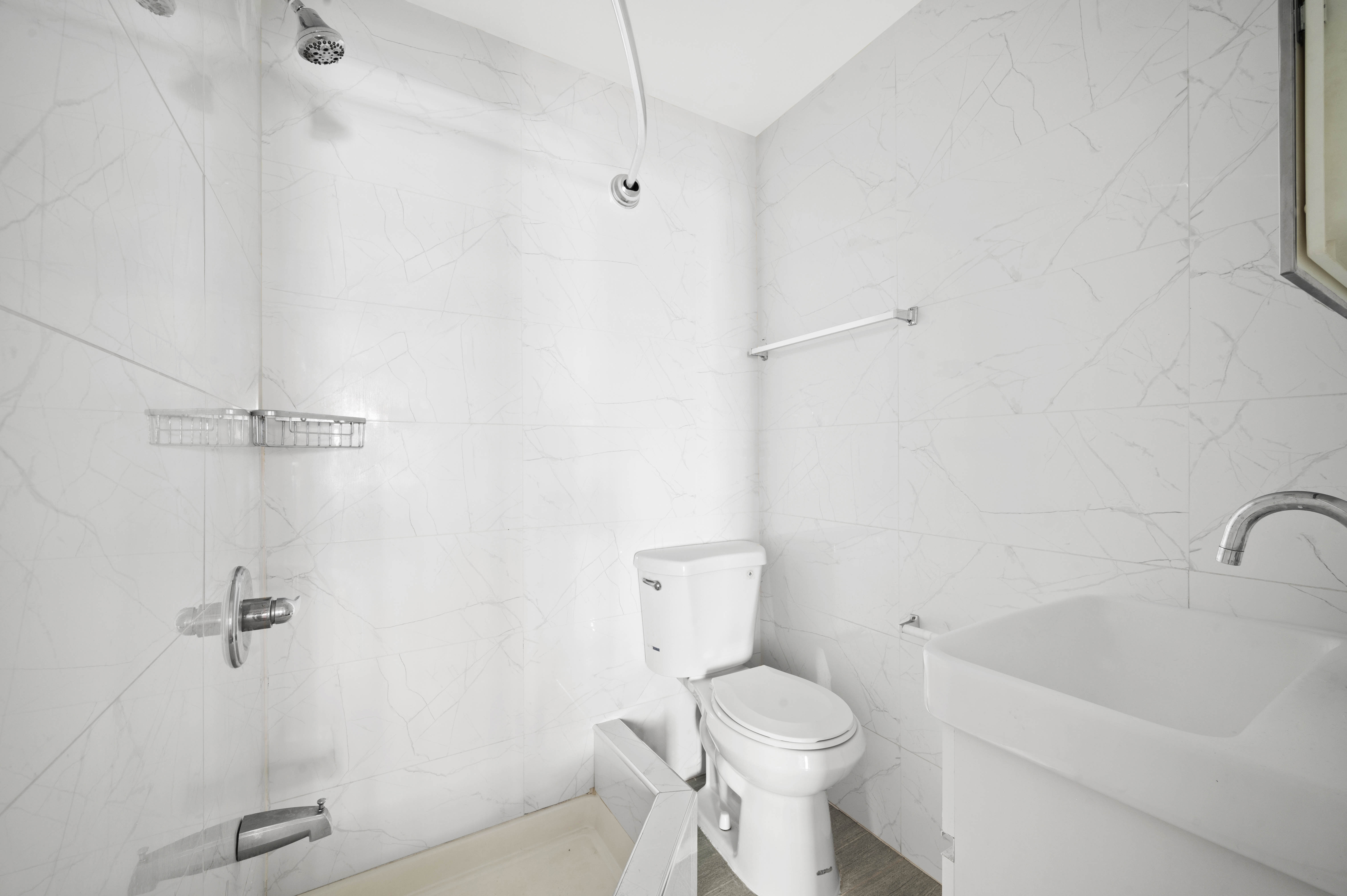 40 East Broadway, Unit 5 Manhattan, NY 10002 - Photo 6 of 10 a white toilet sitting next to a bath tub