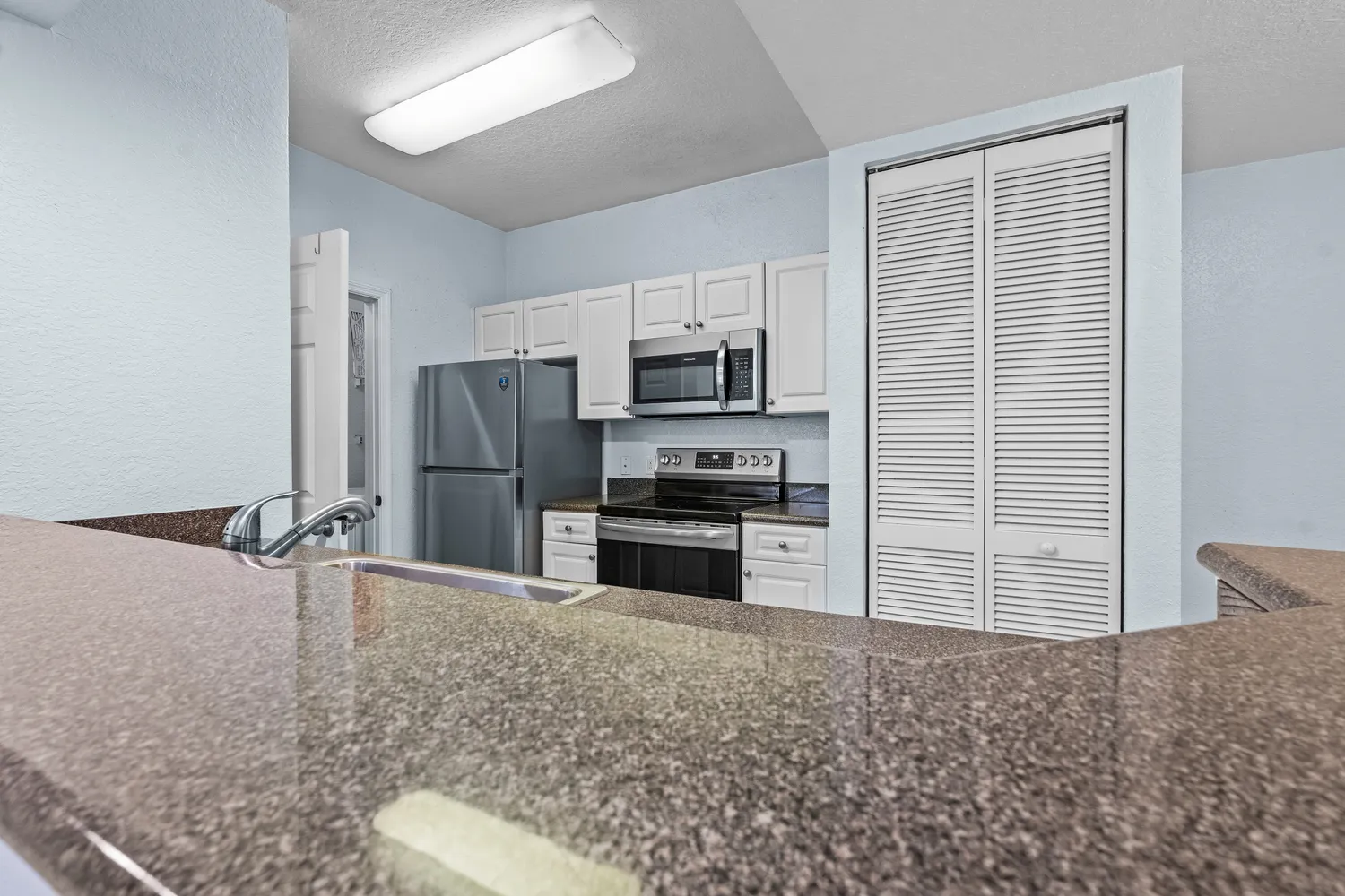 a kitchen with a sink and a refrigerator